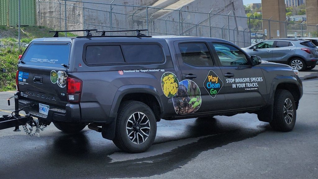 Photo of the NSISC truck with the PlayCleanGo logo and "Stop Invasive Species In Your Tracks" decals on the side.